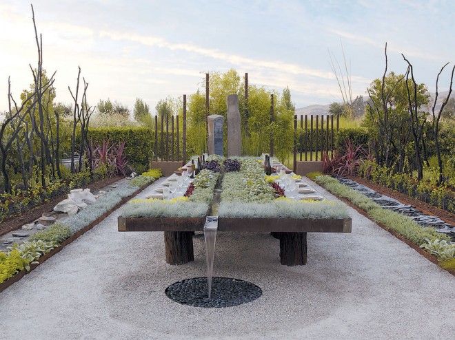 View of Future Feast showing (left) a channel of fossils symbolizing extinction, next to a row of plants that attract birds, butterflies, and bees; (right) a channel of black lava pits that symbolize the depletion of natural resources, fronted by a row of plants that free the earth of toxins