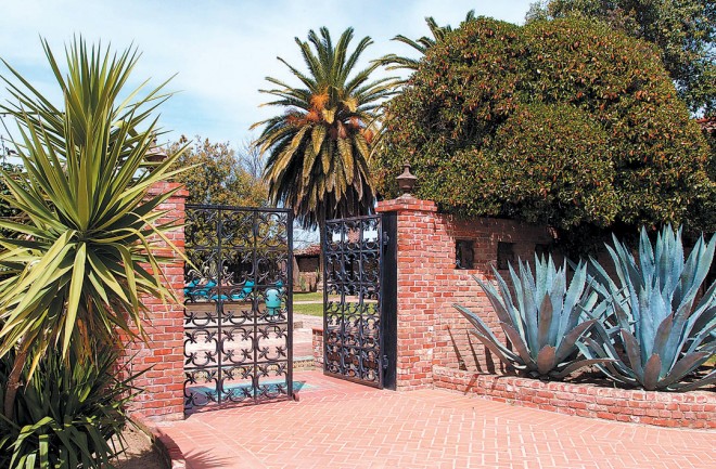 Yucca and agave stand guard either side of of the cast-iron courtyard gates, salvaged from a San Francisco bank