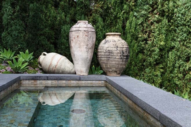 Stone spa accented with ancient Greek and Roman urns and a drift of Agave attenuata. Photo: Doug Jones