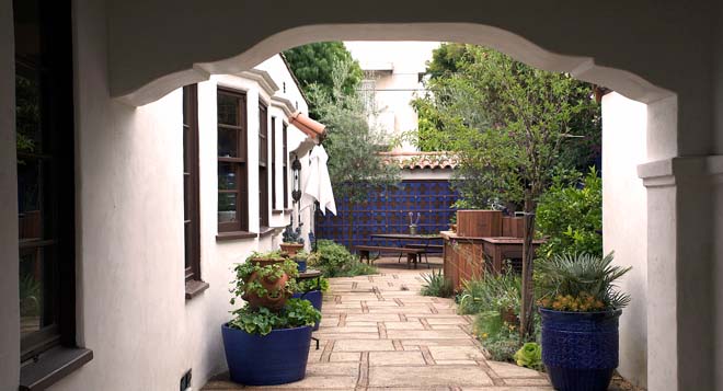 Vivid blue draws the eye down the drive past strawberry and herb plantings toward the outdoor kitchen and dining area. Photo: Jeff Dunas