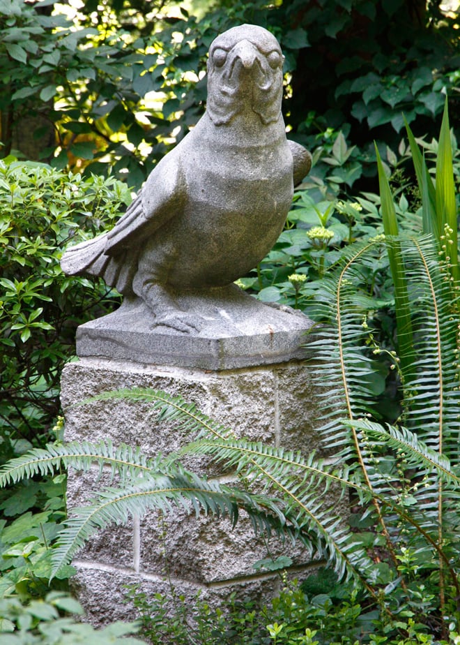 This hefty granite falcon, found in a junk shop, is one of a pair that now guards the garden.  Photo: Sharon Andrews