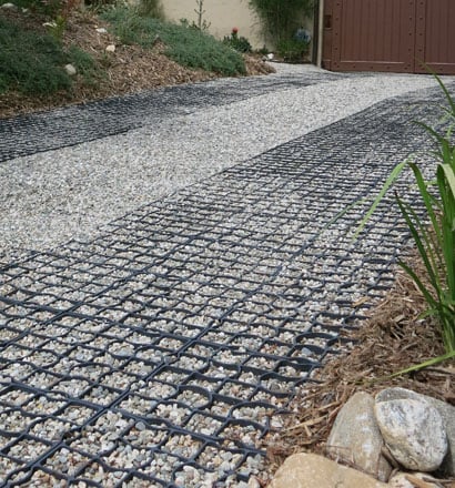 Permeable gravel surfaces finished with StabiliGrid tiles hold gravel in place and provide ADA-compliant wheelchair accessibility for the driveway and garden. Photo: Cordelia Donnelly